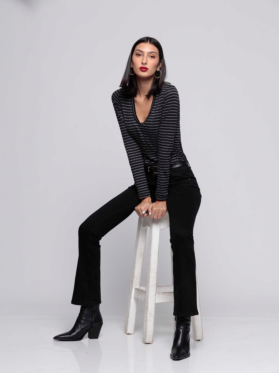 Cava Black Flare Jean — model seated on stool front facing fully styled | Bianco Jeans