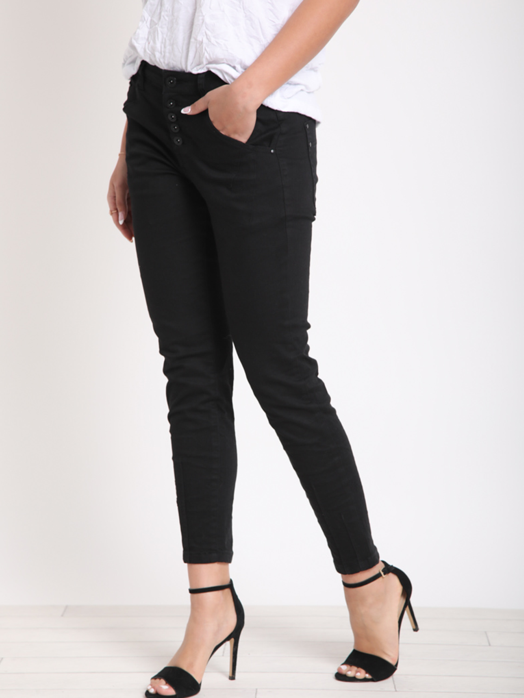 San Luis Black Jean — half body side facing view in motion, ankle length black stretch denim with tapered leg | Bianco Jeans